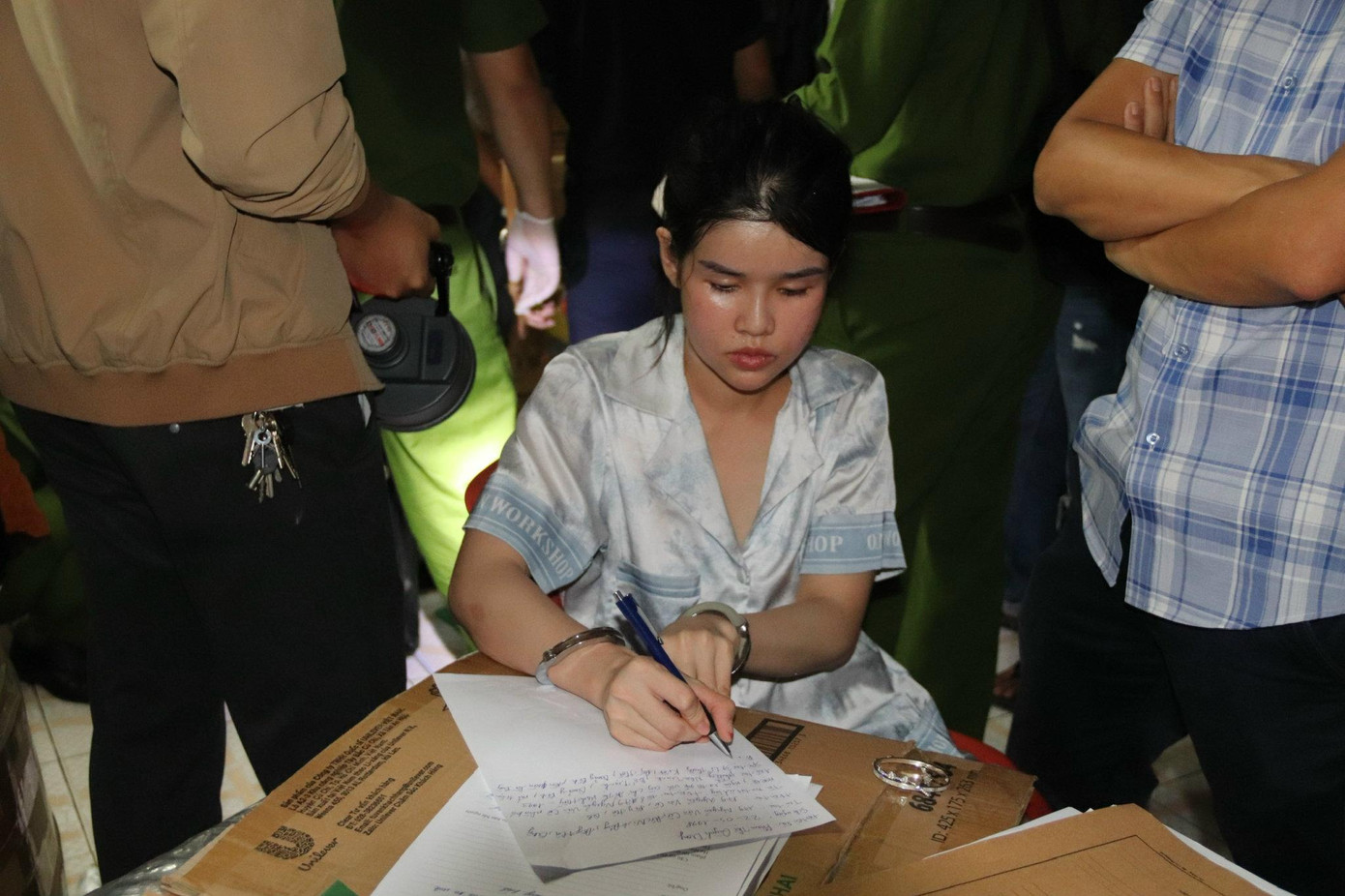 Đối tượng Trang viết lời khai tại hiện trường.