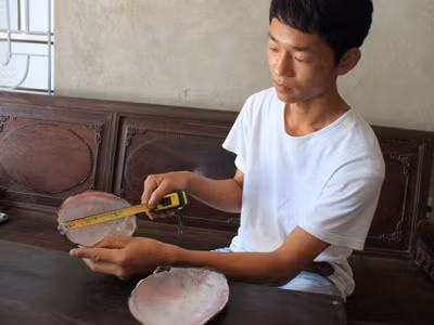 Anh Đỗ Hoàng Tuấn bên chiếc vỏ trai có hạt ngọc. Ảnh: Hoàng Lam