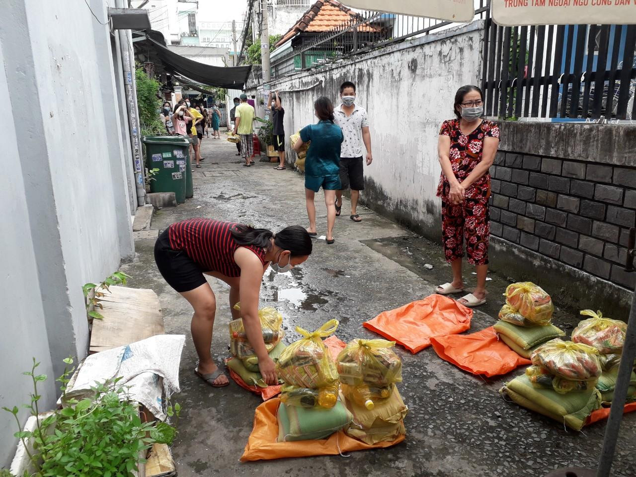 Người dân nghèo đang sinh sống tại các phòng trọ nhận lương thực và nhu yếu phẩm do chính quyền địa phương cung cấp. Ảnh: Huy Thịnh