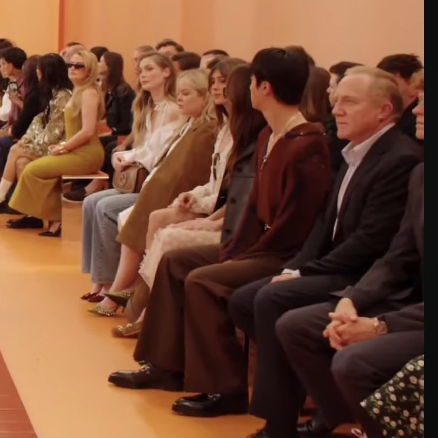 Jin ngồi giữa nữ diễn viên Dakota Johnson và Chủ tịch François-Henri Pinault của Kering.