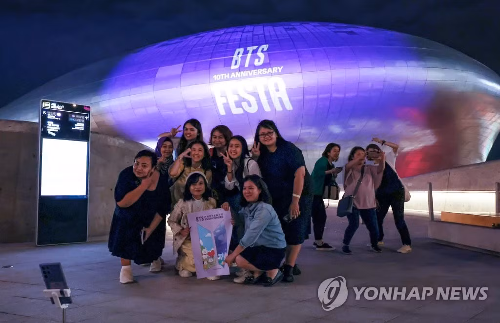Người hâm mộ chụp ảnh kỷ niệm trước Dongdaemun Design Plaza. - Ảnh: Yonhap News