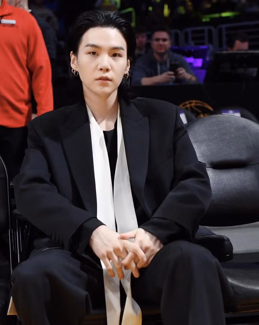 SUGA đã diện suit đến từ BST Maison Valentino Essentials, tham dự trận đấu giữa Lakers và Mavericks tại Crypto Arena.