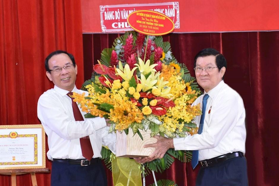 Bí thư Thành uỷ TPHCM Nguyễn Văn Nên (trái) tặng hoa chúc mừng nguyên Chủ tịch nước Trương Tấn Sang. Ảnh: Thành uỷ TPHCM