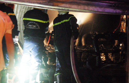 Cảnh sát chữa cháy tích cực dập lửa ở cửa hàng gỗ. Ảnh: An Nhơn