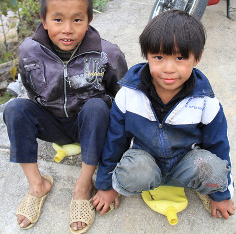 Hai đứa trẻ Giàng Mi Xá, Giàng Mi Chá chơi trò lướt ván trên đường bê tông.