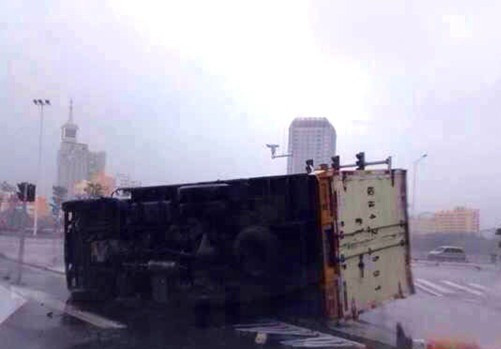 Gió làm lật một xe tải khi nó đang lưu thông trên đường. Ảnh: hinews.cn