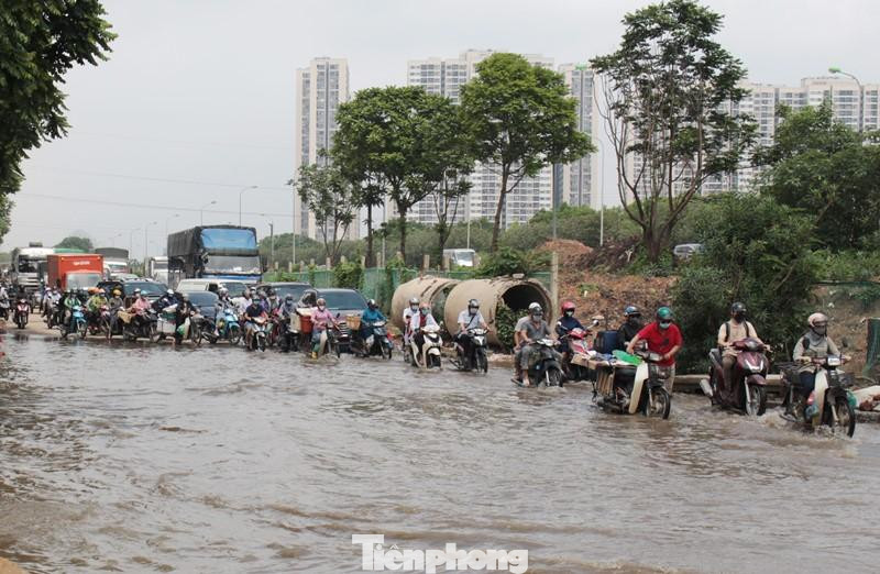 Ngập úng khiến lượng xe xếp hàng đi qua, một số xe 2 bánh chết máy, người điều khiển phải lội nước dắt bộ.