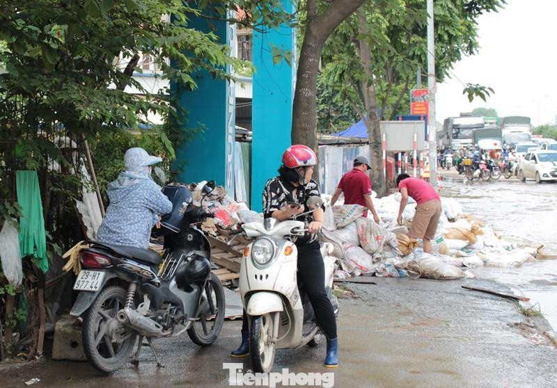 Do ngập sâu, nhiều chủ phương tiện xe máy là nữ điều khiển đã không dám "phiêu liêu" đi qua khu vực ngập, đành đứng bên vệ đường để tìm hướng di chuyển mới.