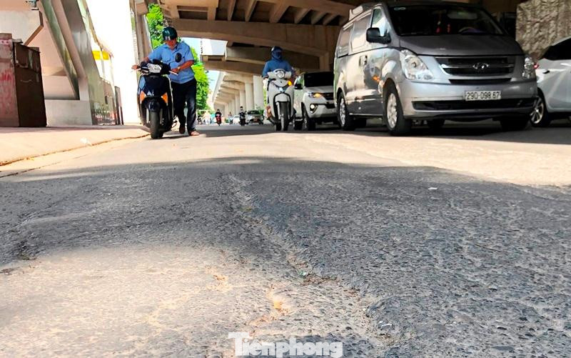 Người đi đường thường xuyên là nạn nhân của những chiếc đinh nhọn khi bánh xe máy, ô tô chèn phải, gây thủng săm, lốp. Trong ảnh, một người đi xe máy phải xuống dắt xe khi đi qua mặt đường Hồ Tùng Mậu đoạn qua trường Sân khấu Điện ảnh.