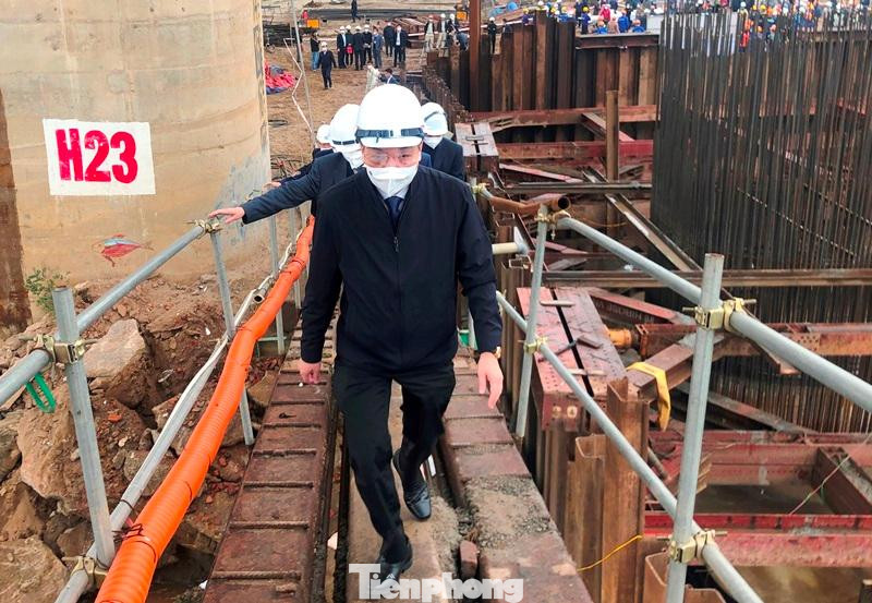 Sau khi thăm hỏi, chúc tết công nhân thi công dự án, Chủ tịch UBND thành phố Hà Nội đã đi lên cầu dẫn ra công trường đổ các trụ cầu chính nằm giữa sông Hồng.
