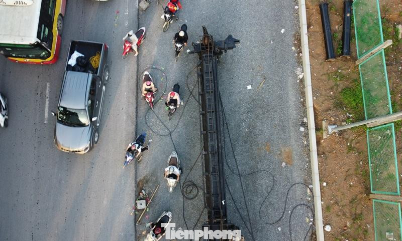 Thậm chí khi ùn tắc, nhiều người đi xe máy còn bất chấp nguy hiểm, đi vào công trường dự án với nhiều dây điện loằng ngoằng dưới mặt đường.