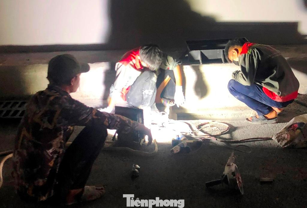 Hiện đơn vị thi công đang lắp hệ thống điện chiếu sáng, thoát nước, sơn kẻ vạch phân luồng, phân làn giao thông. Trong ảnh: Chiều 28/9, do bên trong hầm chưa có điện nên công nhân thi công phải dùng pha đèn di động chiếu sáng để làm việc. Hiện đơn vị thi công đang lắp hệ thống điện chiếu sáng, thoát nước, sơn kẻ vạch phân luồng, phân làn giao thông. Trong ảnh: Chiều 28/9, do bên trong hầm chưa có điện nên công nhân thi công phải dùng pha đèn di động chiếu sáng để làm việc.