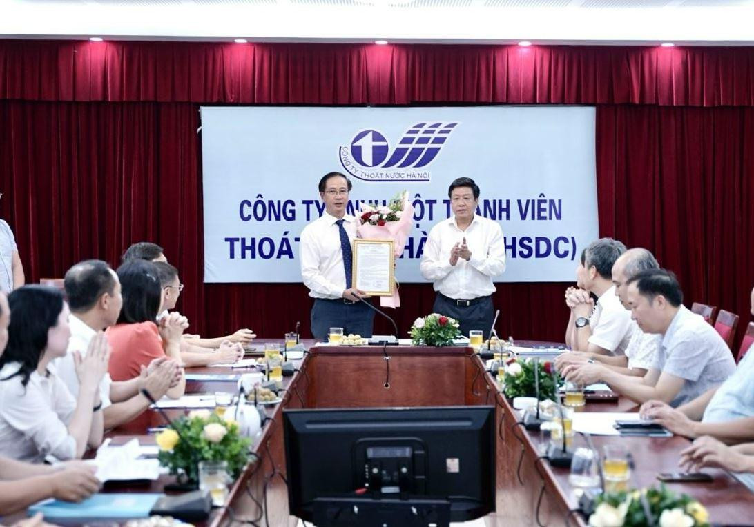 Ông Phan Hoài Minh (người ôm hoa), nhận Quyết định làm Tổng Giám đốc Cty Thoát Nước Hà Nội từ Phó Chủ tịch UBND thành phố Dương Đức Tuấn.