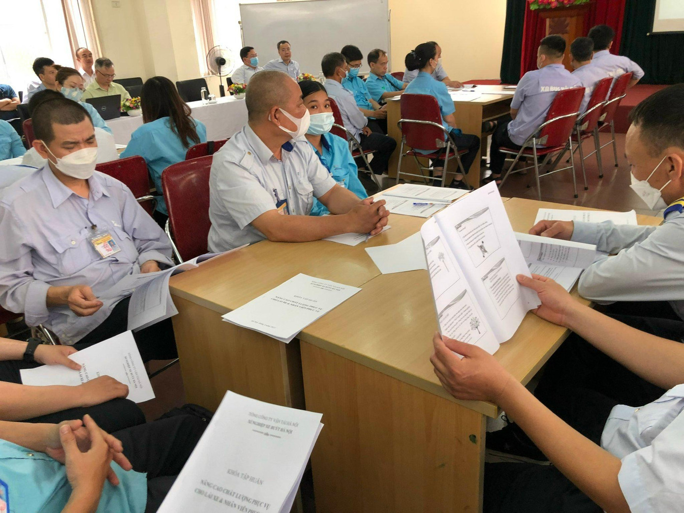 Học viên là các lái, phụ xe buýt nghe giảng và nghiên cứu giáo trình trong lớp học.