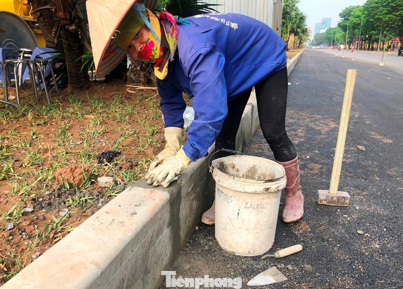 Trưa 26/4, mặc dù trời nắng nhưng một chị công nhân của đơn vị thi công vẫn miệt mài trà trát mạch bó vỉa dải phân cách, hoàn thiện phần đường mở rộng tại đoạn trước Học viện Chính trị Quốc gia Hồ Chí Minh.