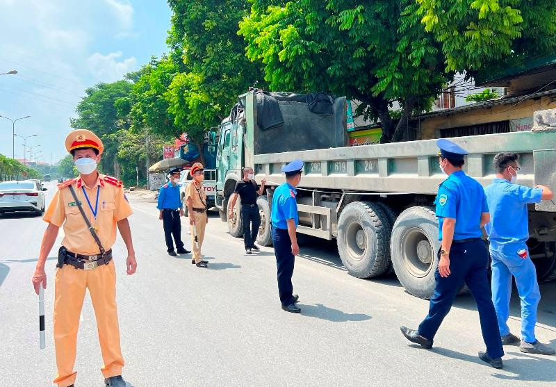 Thanh tra giao thông và CSGT kiểm tra, xử lý và hạ kích thước thành thùng vi phạm xe tải ngay trên đường. Ảnh: Anh Trọng