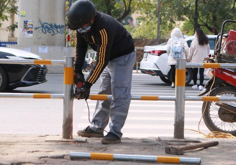 Hàng rào sắt "bịt" kín vỉa hè Hồ Tùng Mậu vừa được công nhân thi công cắt một số đoạn để mở lối lên xuống. Hàng rào sắt "bịt" kín vỉa hè Hồ Tùng Mậu vừa được công nhân thi công cắt một số đoạn để mở lối lên xuống.