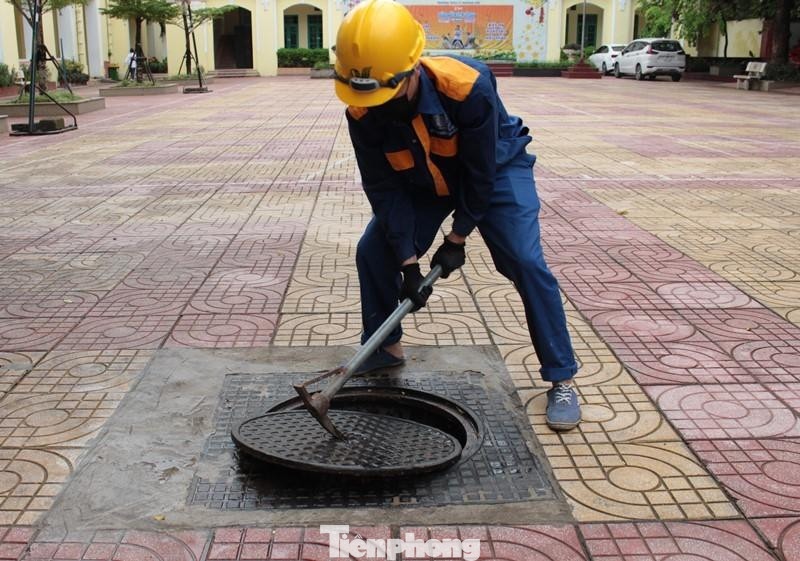 Hầm nằm âm dưới sân trường THCS Lý Thường Kiệt, quận Hoàn Kiếm, Hà Nội. Ngày 6/6, nhân viên vận hành hầm đã khơi, mở nắp hầm chính để PV Tiền Phong ghi nhận.