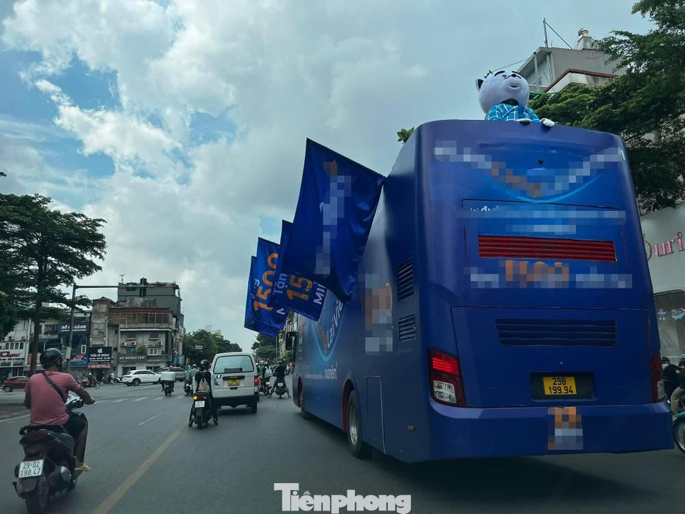Xe khách 29B-19994 trùm kín decal quảng cáo, thành xe treo cờ ngang 2 bên vô tư diễu phố Hà Nội trong ngày 16/8.