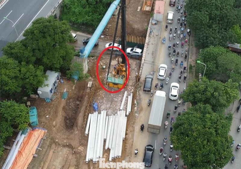 Nhân viên lái máy cẩu đang ngồi vận hành để nâng hạ các cột bê tông. Nhân viên lái máy cẩu đang ngồi vận hành để nâng hạ các cột bê tông.