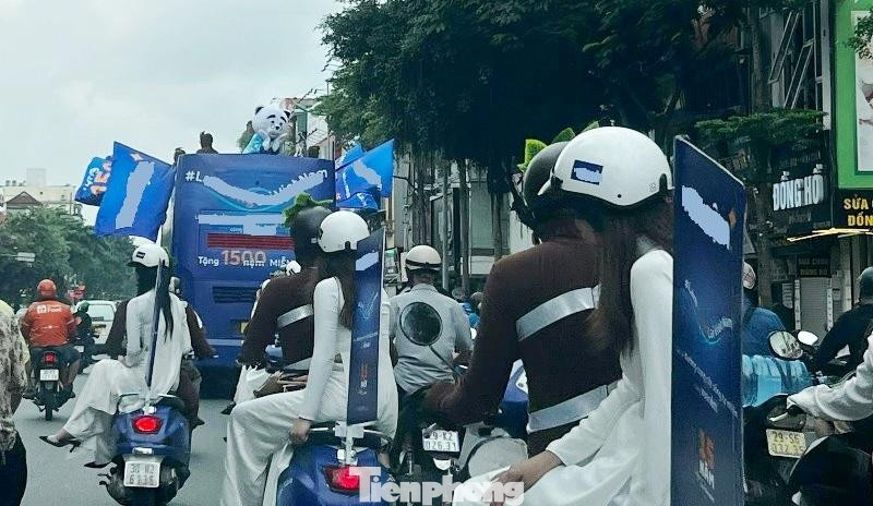 Đi sau xe khách BKS 29B-19994 còn có đoàn xe máy có 2 người ngồi trên, phía sau cũng cắm cờ quảng cáo lưu thông chiếm gần 2 làn đường.