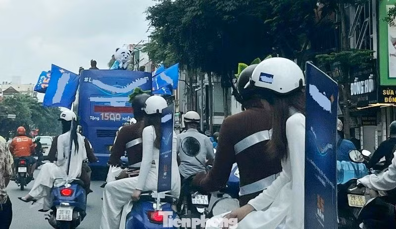 Đi sau xe khách BKS 29B-19994 còn có đoàn xe máy có 2 người ngồi trên, phía sau cũng cắm cờ quảng cáo lưu thông chiếm gần 2 làn đường.