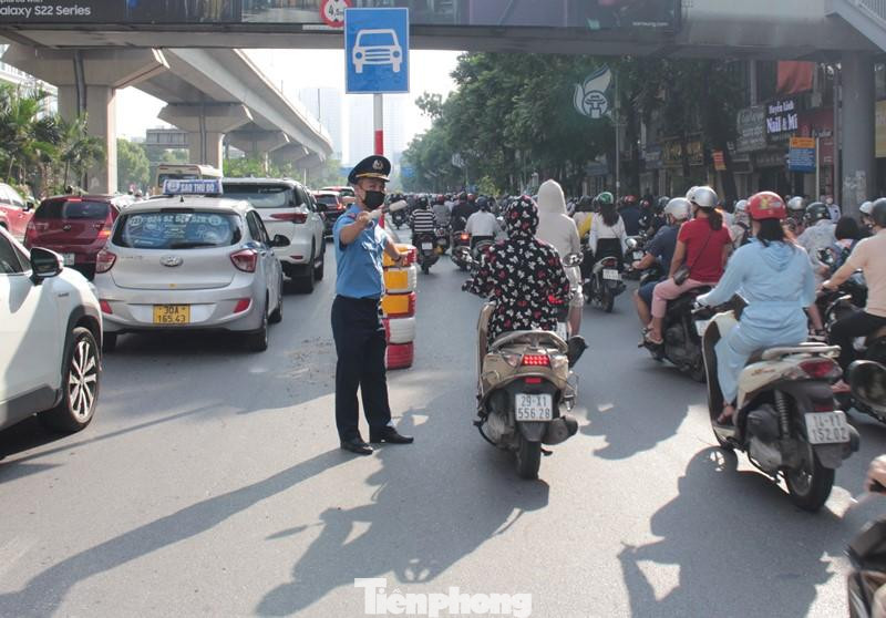 Có biển báo, dải phân cách nhưng Thanh tra giao thông vẫn luôn tay ra hiệu, vẫy công cụ để xe đi theo làn được phân tách.