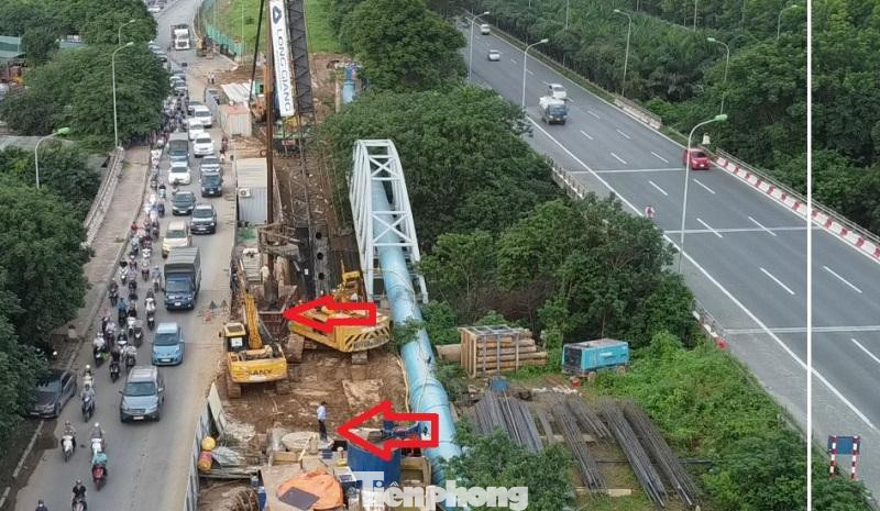 Nhân viên thi công đứng giám sát công nhân lái máy cẩu nâng hạ (mũi tên) đổ trụ bê tông. Nhân viên thi công đứng giám sát công nhân lái máy cẩu nâng hạ (mũi tên) đổ trụ bê tông.