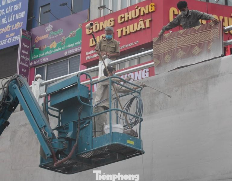 Công nhân thi công phủ phun sơn chống thấm cho lớp áo tường chắn hầm chui. Công nhân thi công phủ phun sơn chống thấm cho lớp áo tường chắn hầm chui.