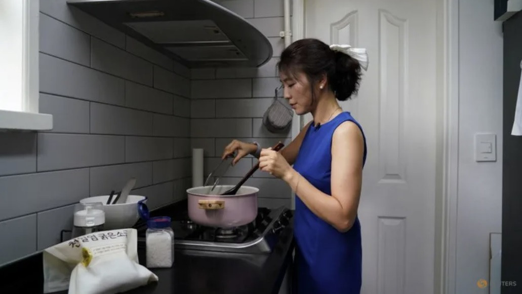 Chị Lee Young-min đang nấu canh rong biển cho gia đình. (Ảnh: Reuters)
