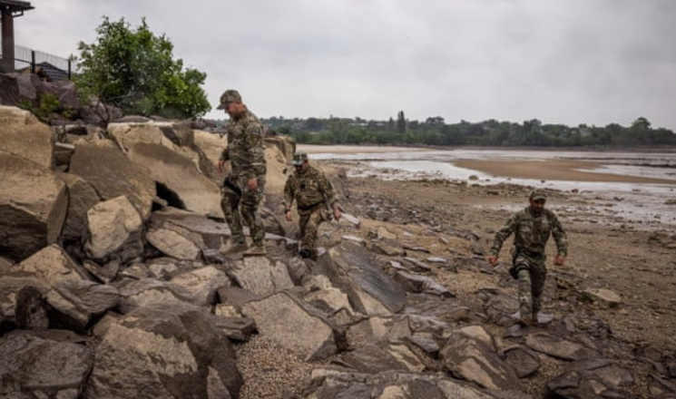 Binh lính đi bộ bên dòng sông Dnipro ở Novovorontsovka. (Ảnh: Guardian)