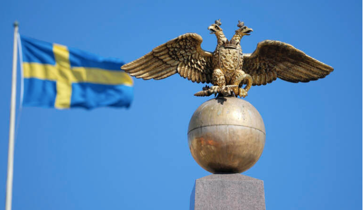 Hình ảnh đại bàng hai đầu trên Quốc huy Nga trước Quốc kỳ Thuỵ Điển trên Quảng trường ở Helsinke, Phần Lan. (Ảnh: AP) Hình ảnh đại bàng hai đầu trên Quốc huy Nga trước Quốc kỳ Thuỵ Điển trên Quảng trường ở Helsinke, Phần Lan. (Ảnh: AP)