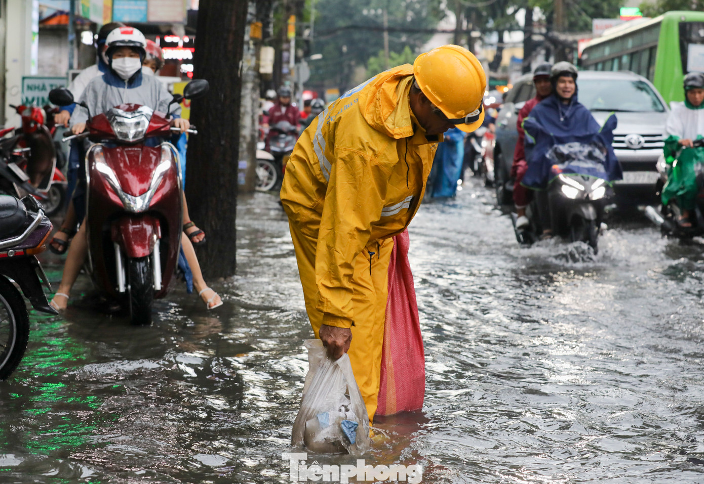 Công nhân vệ sinh làm việc hết công suất để móc các túi ra ra khỏi miệng cống để tuyến đường mau thoát nước.
