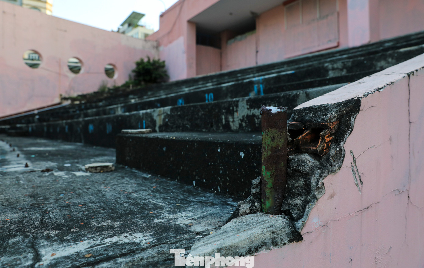 Khu vực khán đài (bậc tam cấp) đã tháo dỡ tấm gỗ lót màu, phủ đầy rong rêu.