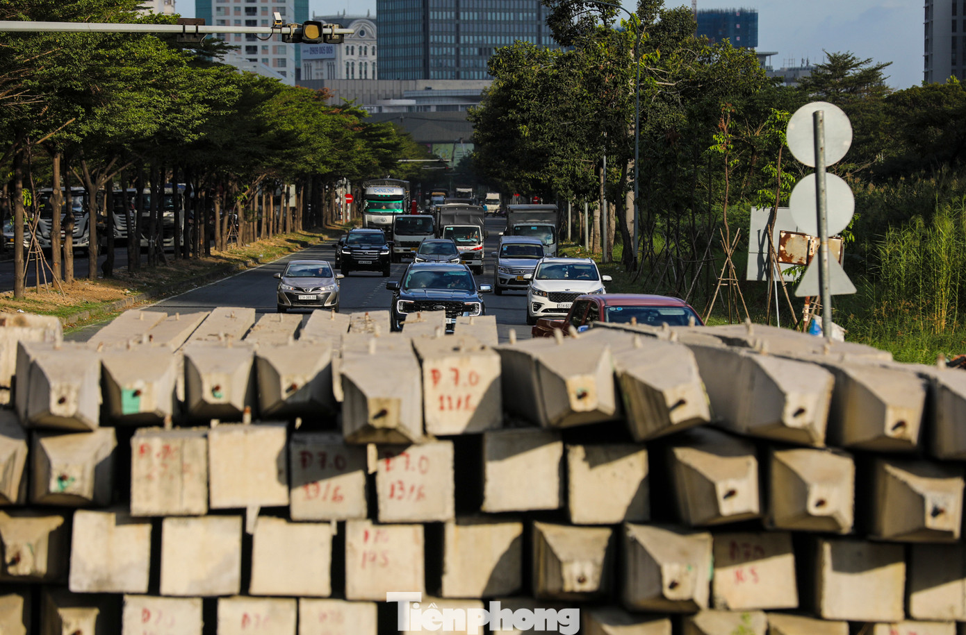Phần lòng đường bị cắt ngang do rào chắn công trình và vật liệu xây dựng khiến xe cộ phải cua sang làn khác.