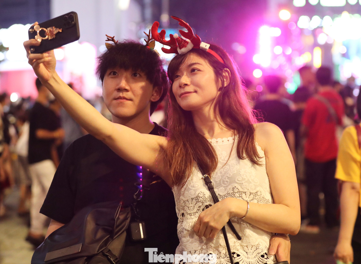 Cặp đôi người Hàn Quốc thích thú lưu lại khoảnh khắc đáng nhớ của đêm giáng sinh tại TPHCM.