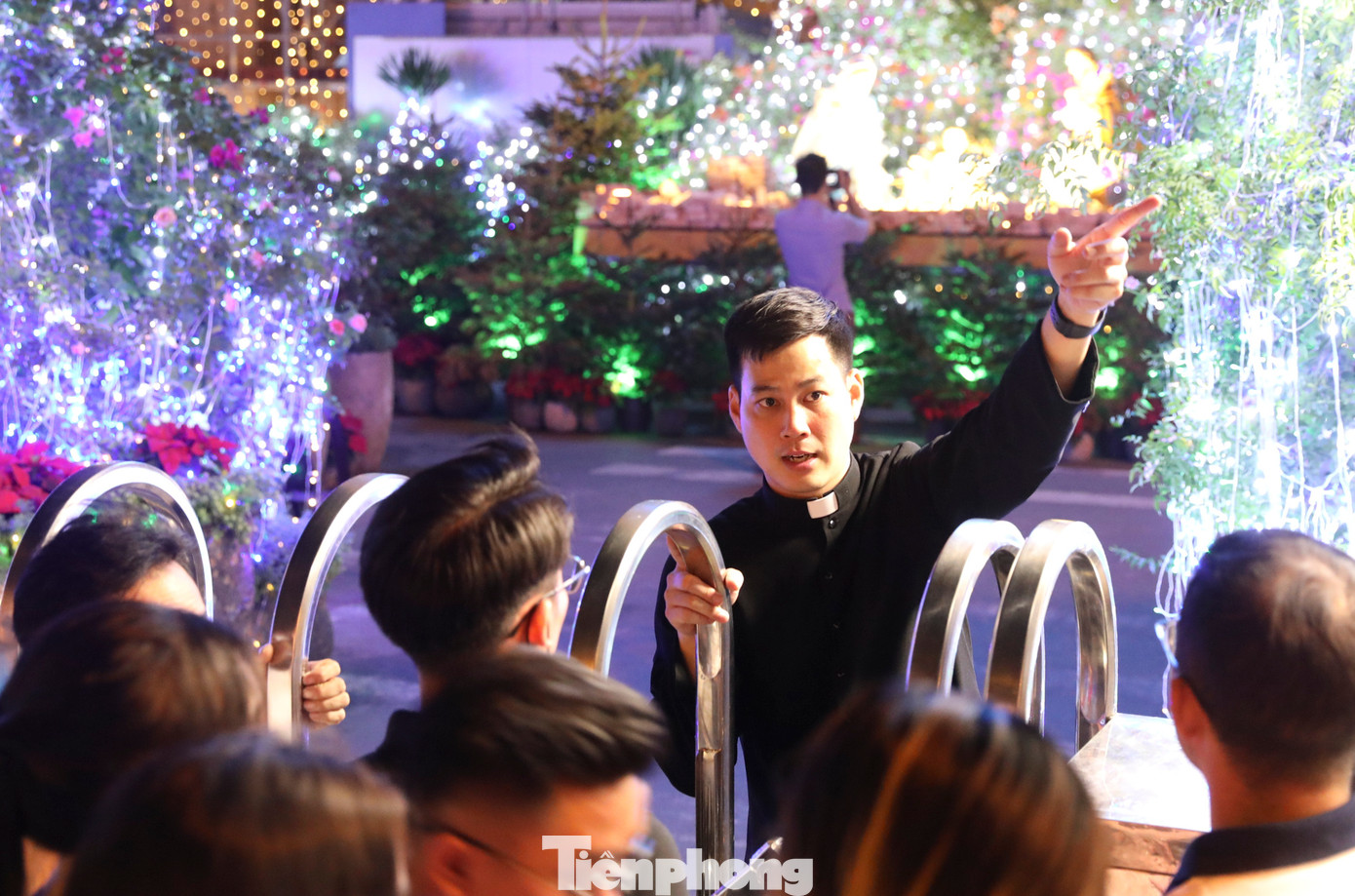 Cha xứ tại nhà thờ Đức Bà hướng dẫn du khách xếp hàng để có thể vào bên trong nhà thờ chụp những tấm hình lưu niệm nhân dịp Giáng sinh.