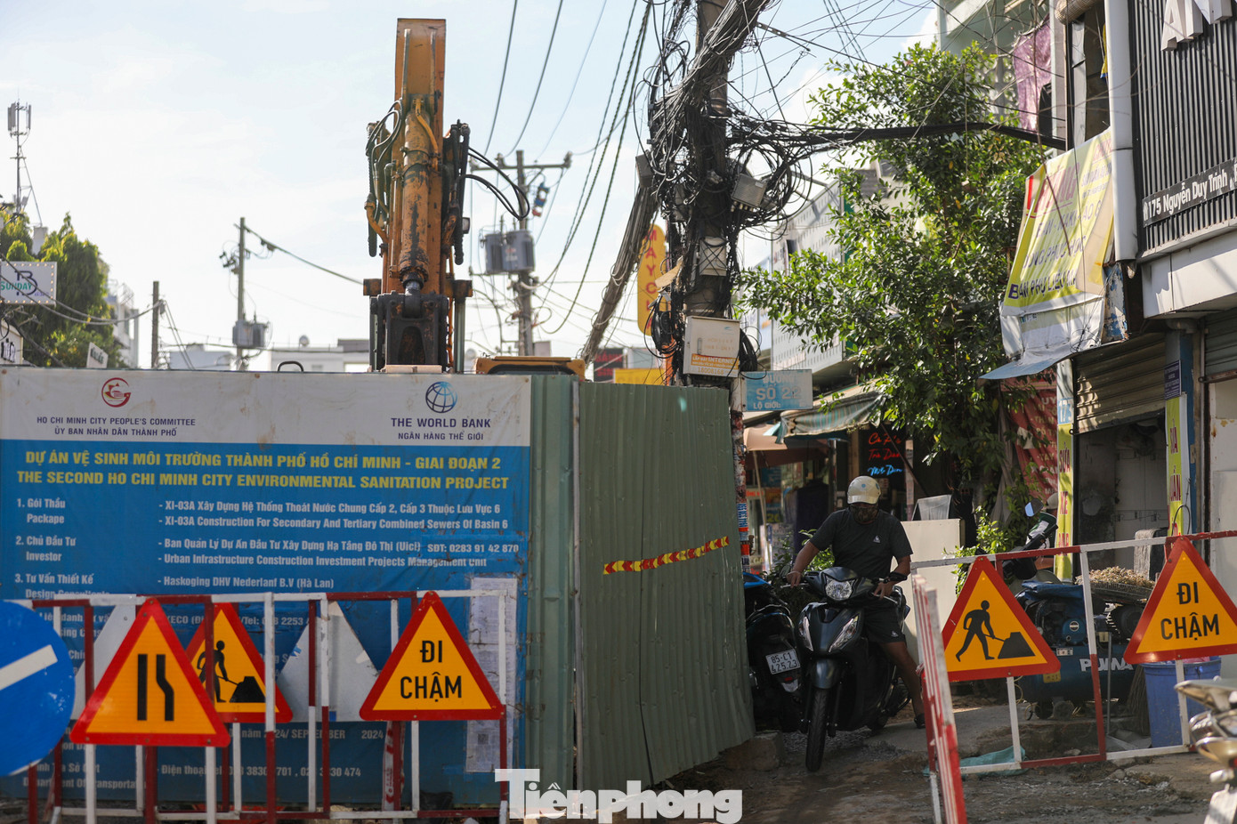 Người dân đi đường Nguyễn Duy Trinh (TP Thủ Đức) gặp nhiều vất vả do lô cốt của dự án vệ sinh môi trường TP.HCM (giai đoạn 2) chiếm hơn nửa mặt đường trong hơn một tháng qua.