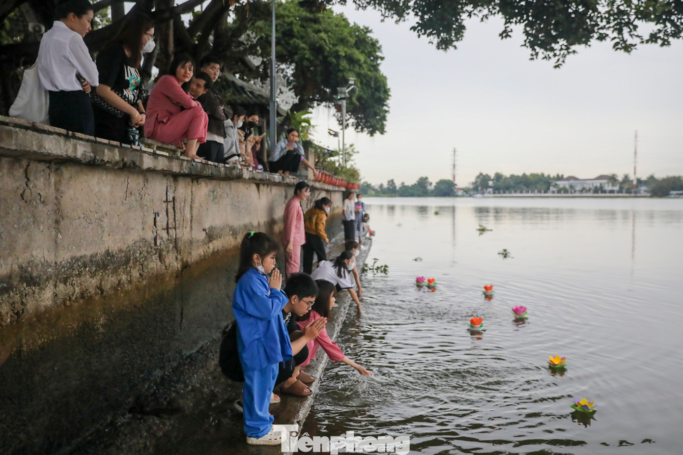 Trời mưa, thành bờ sông kế bên chùa khá trơn trượt nhưng nhiều người vẫn không ngại bước xuống để tận tay thả hoa đăng.