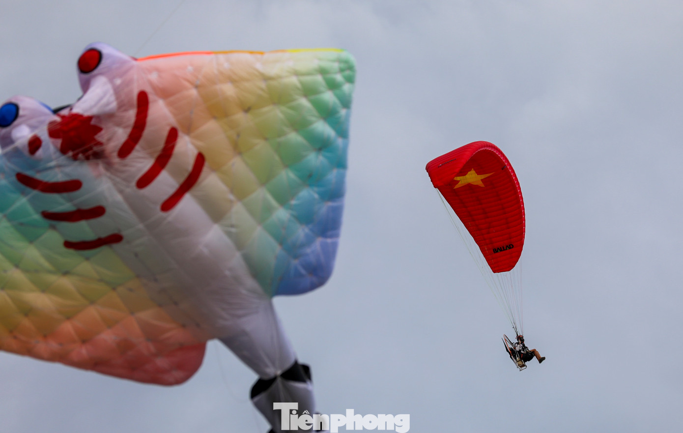 Một chiếc dù lượn mang hình quốc kỳ tung bay trong không trung.