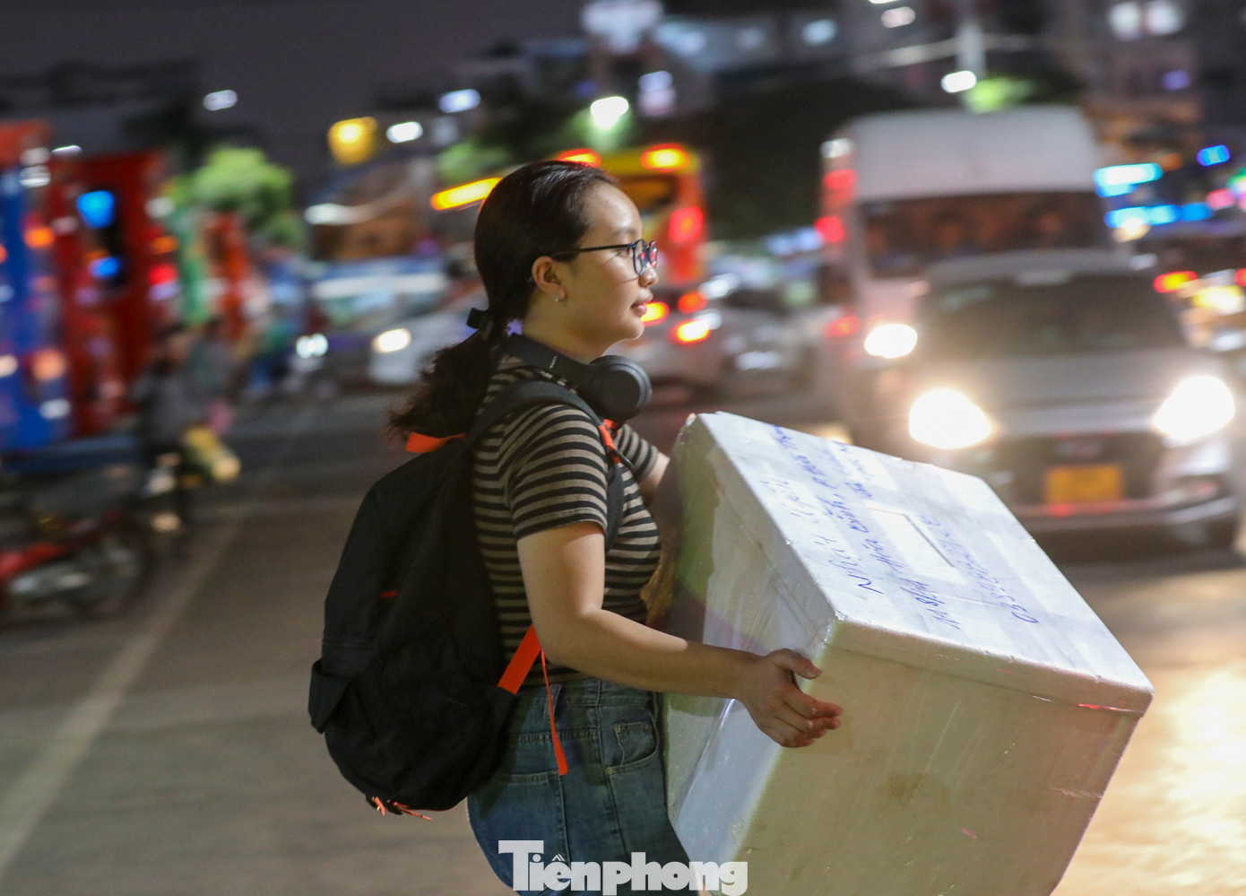 Một bạn trẻ tay xách nách mang hành lý vội vã ra xe cho kịp chuyến.