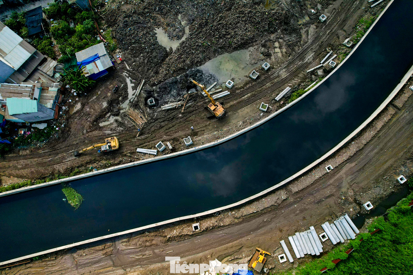 Máy xúc tiến hành nạo vét bùn đất dưới rạch, chất lên xe tải chở đến nơi tập kết. Công nhân hàn khung sắt tạo cống hộp qua rạch Bà Tiếng.