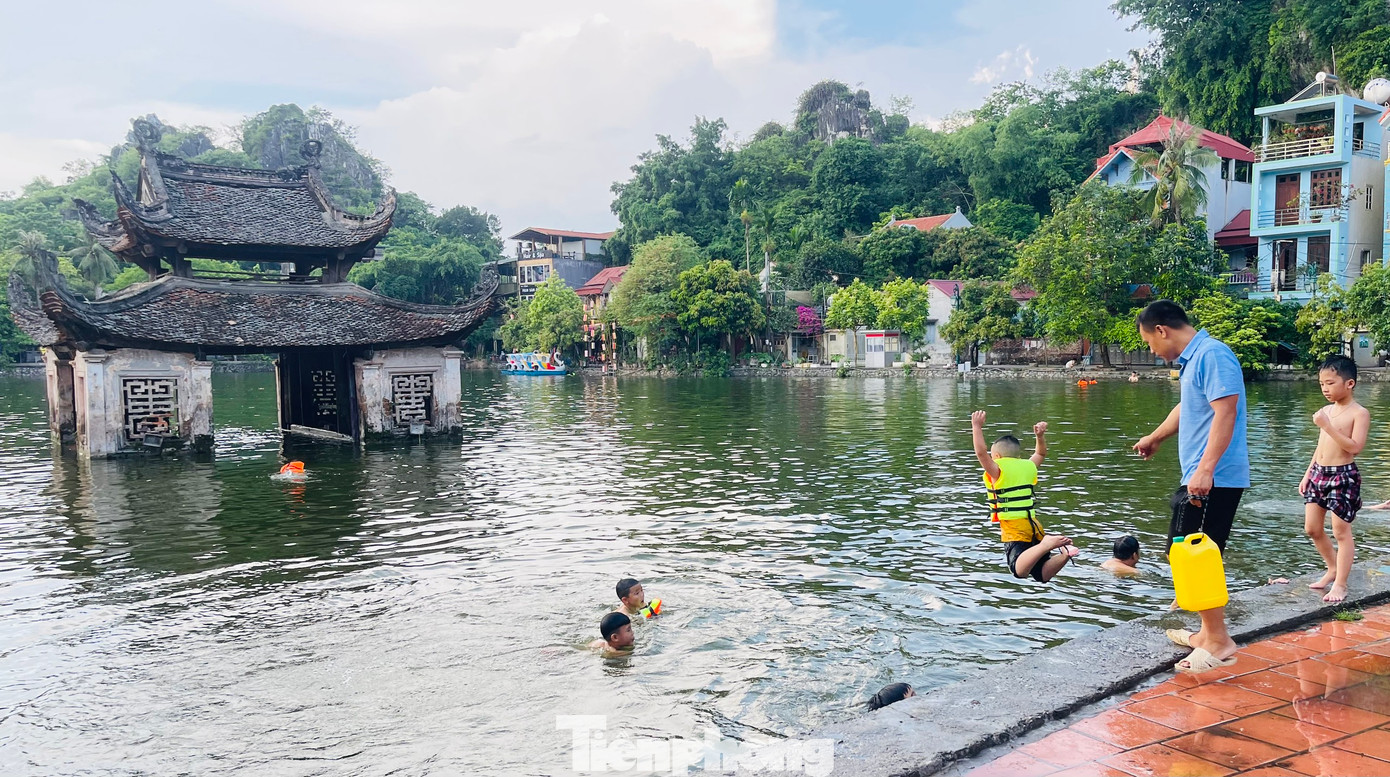 Những ngày cuối tuần nắng nóng oi bức này, lòng hồ Long Trì nằm trong khuôn viên khu di tích Chùa Thầy (huyện Quốc Oai, Hà Nội) lại trở thành “bể bơi” khổng lồ miễn phí giải nhiệt cho hàng trăm người mỗi ngày.