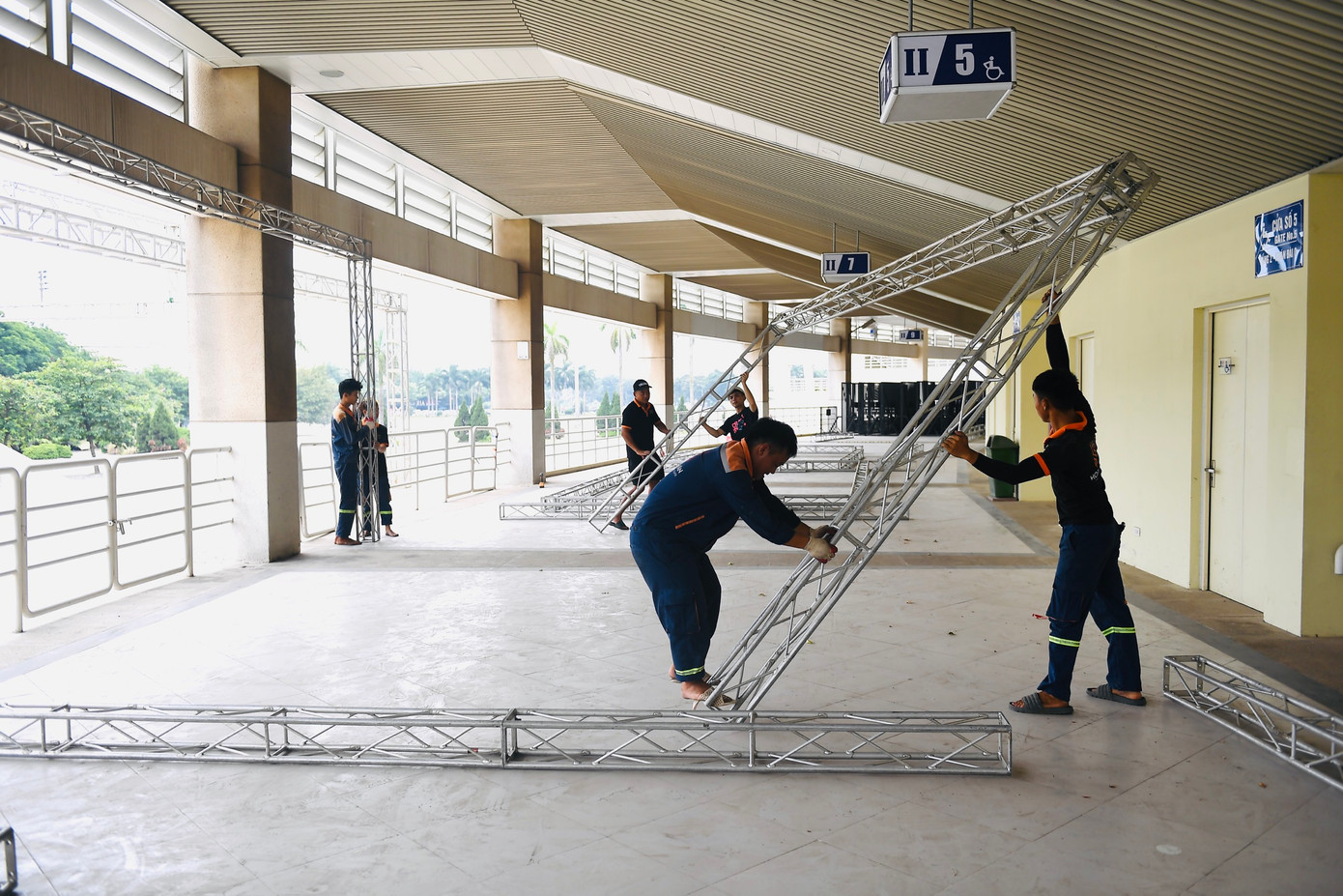 Phía trước sảnh sân vận động, các hạng mục như gian hàng quảng bá, khu vực khán giả xếp hàng kiểm soát vé để vào trong đang được gấp rút hoàn thành.