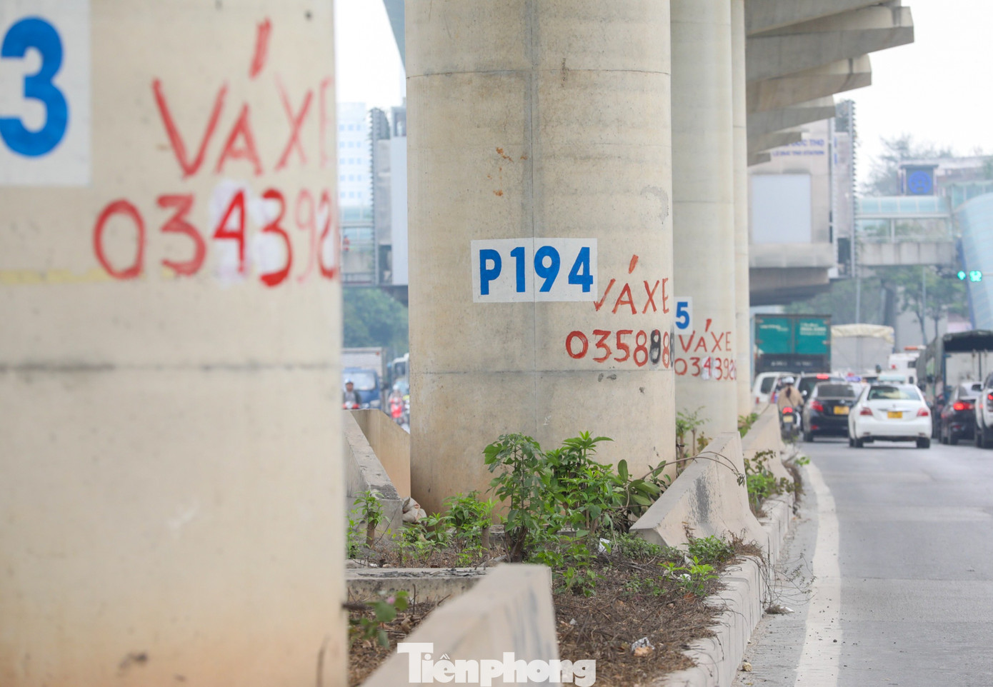 Nhiều trụ bê tông bị vẽ chi chít các số điện thoại, dán tờ rơi quảng cáo dán xung quanh.