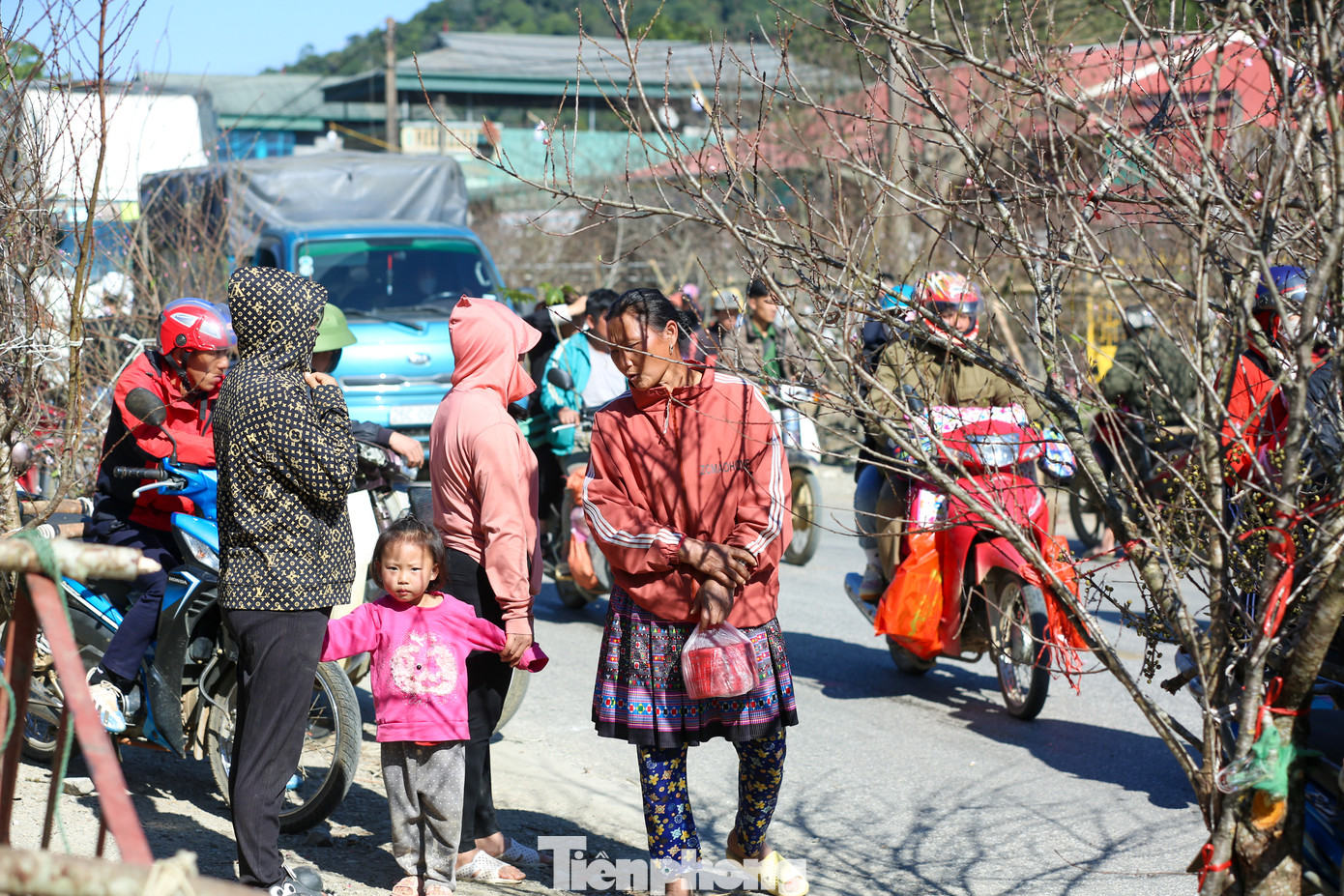 Các em nhỏ theo mẹ xuống chợ đào Tết.