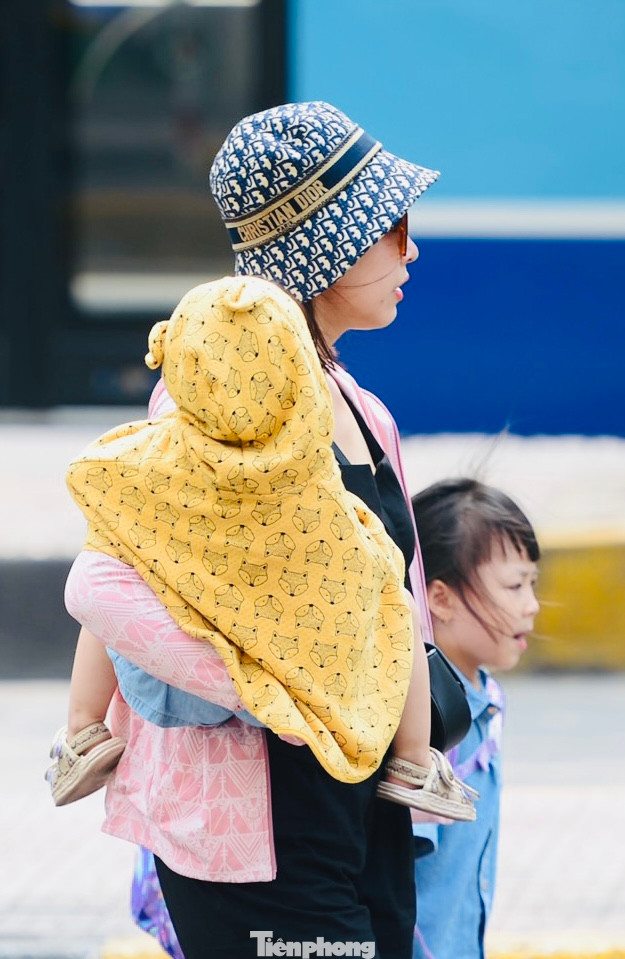 Thời tiết nắng nóng cũng khiến các gia đình di chuyển vào bến xe, đợi chuyến thêm phần vất vả hơn.