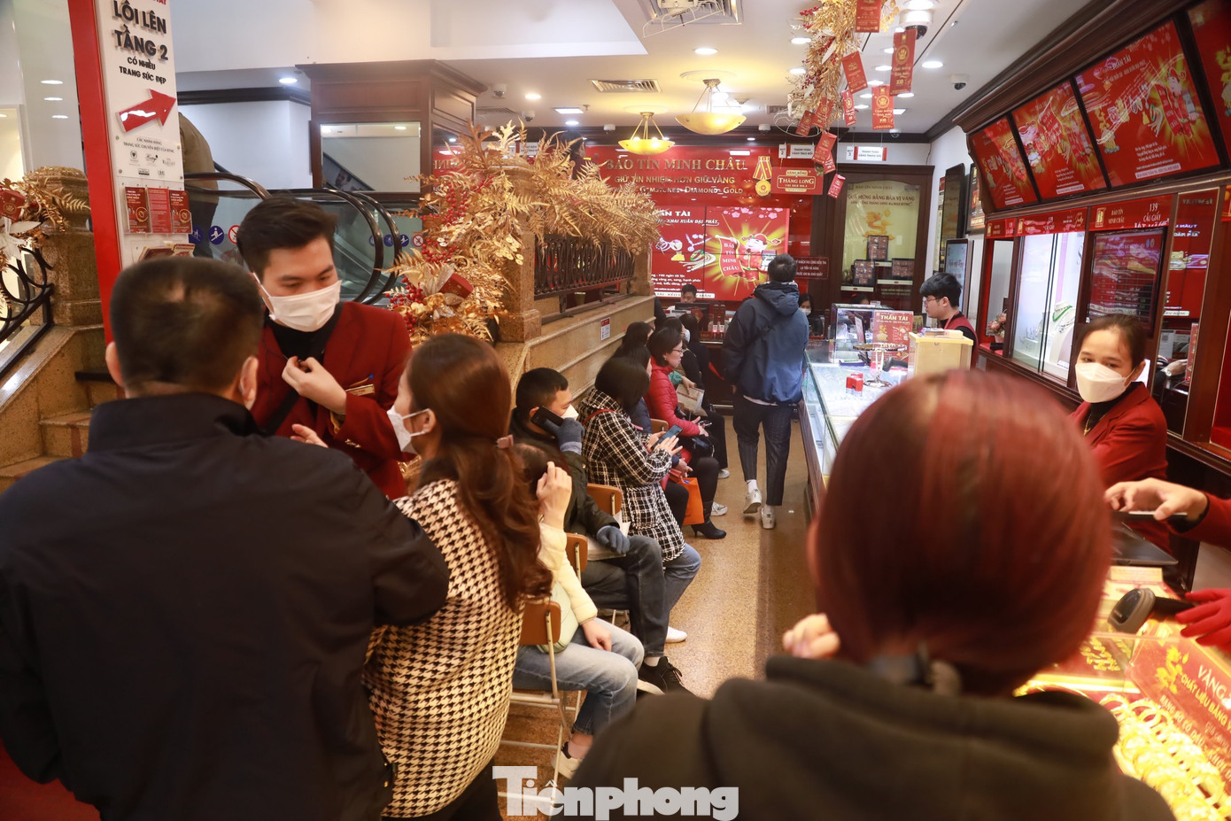 Nhiều người dân xếp hàng ngồi chờ để được thanh toán, mua vàng ở cửa hàng Bảo Tín Minh Châu vào trưa ngày 30/1.