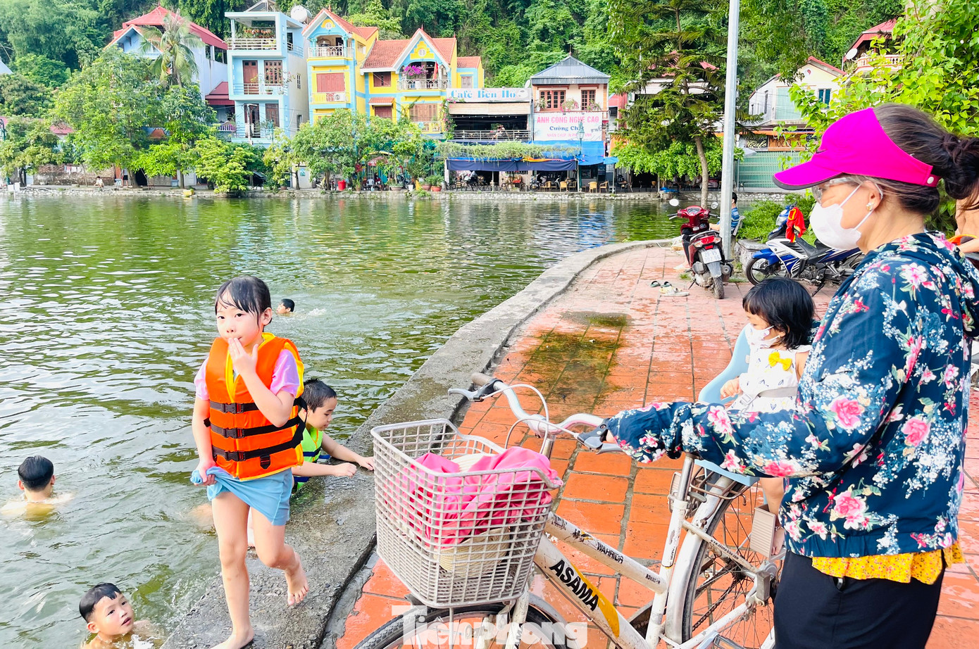 Rất đông người dân đưa con ra hồ Long Trì để tắm giải nhiệt, phần lớn là các em độ tuổi 5-15 tuổi. Trong đó, có nhiều em nhỏ chưa hề biết bơi và được các phụ huynh hướng dẫn tập bơi, cũng như được trang bị áo phao.