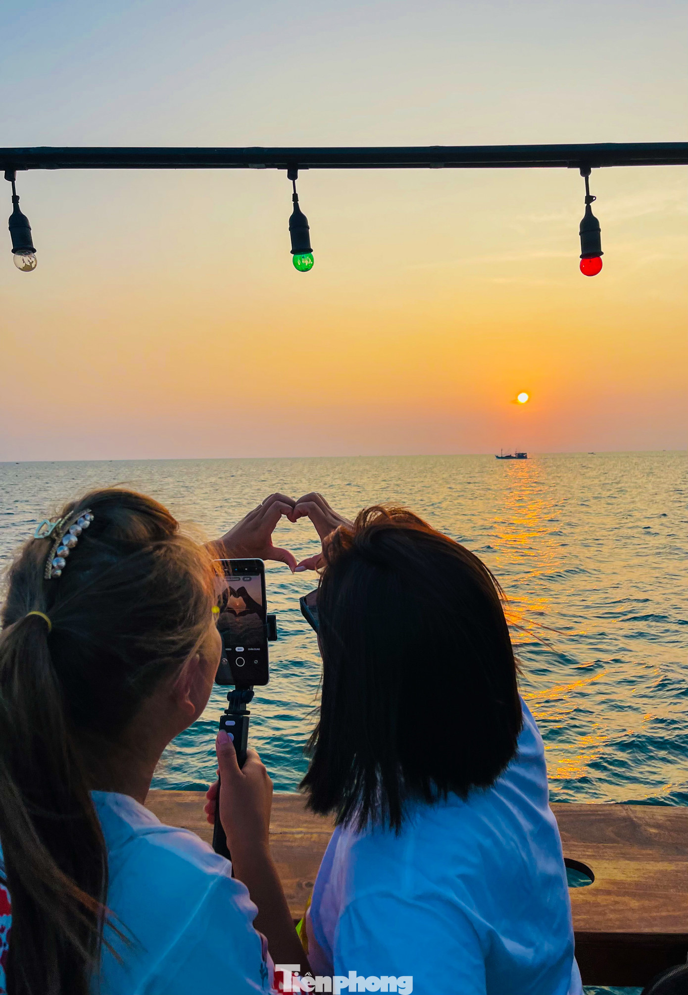 Các du khách hào hứng tranh thủ check-in với ánh hoàng hôn tuyệt đẹp trên biển.